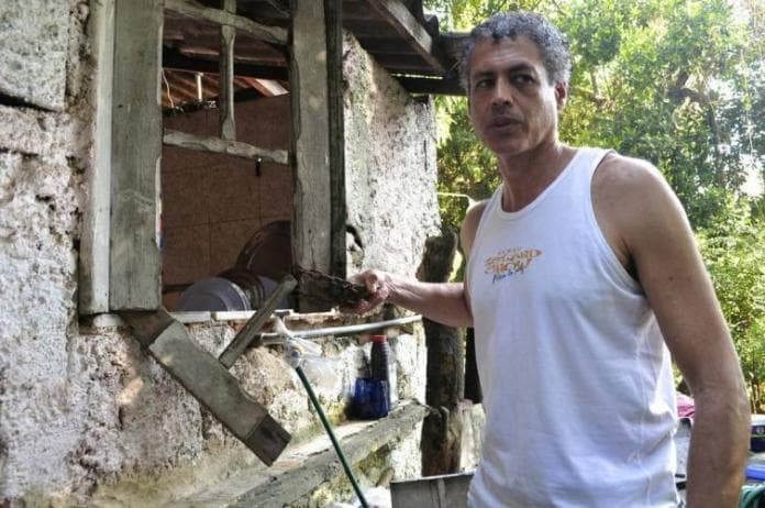José Claudio Pinto segura o cadeado que costumava trancar portas e janelas. (Carolina Ramirez/The Huffington Post)
