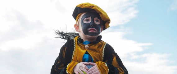 A Dutch child wearing blackface make up is carried during a demonstrate in The Hague, Netherlands on Saturday, Oct. 26, 2013, to show their determination to keep alive a tradition of allowing actors to wear blackface makeup during the countrys annual St. Nicholas festival for children. A vocal minority of Dutch people, especially of African descent, and many observers in the rest of the world think the Black Pete tradition is offensive, given Petes appearance includes curly hair, big red lips and black face-paint. But a large majority of Dutch people say Black Pete is a figure of fun and no racial insult is intended. (AP Photo/ Patrick Post)