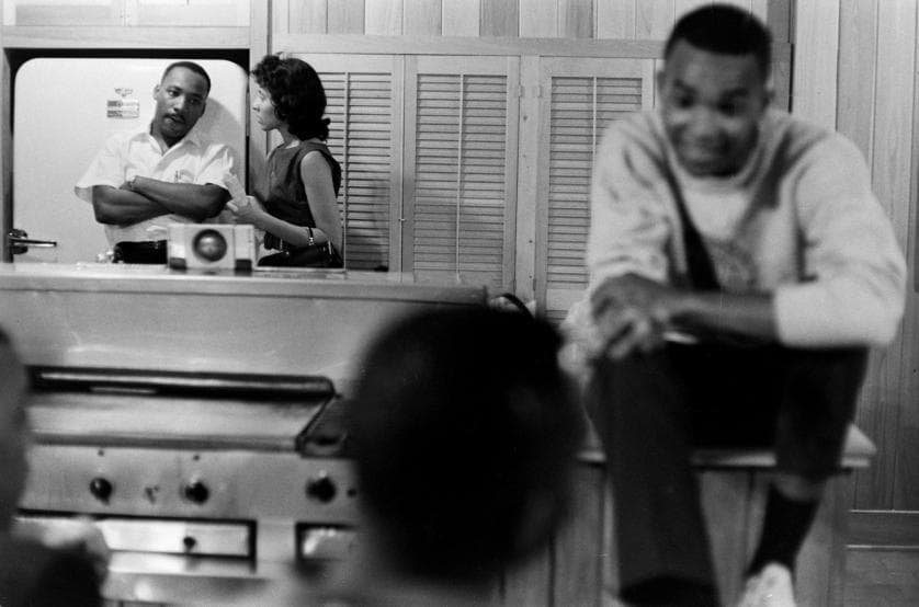 The Freedom Riders: The Reverend Dr. Martin Luther King Jr. looks tense, perhaps worried, in the kitchen of a safe house. As a volunteer bends his ear, the 32-year-old civil rights leader glances toward one of the 17 students hunkered down with him.