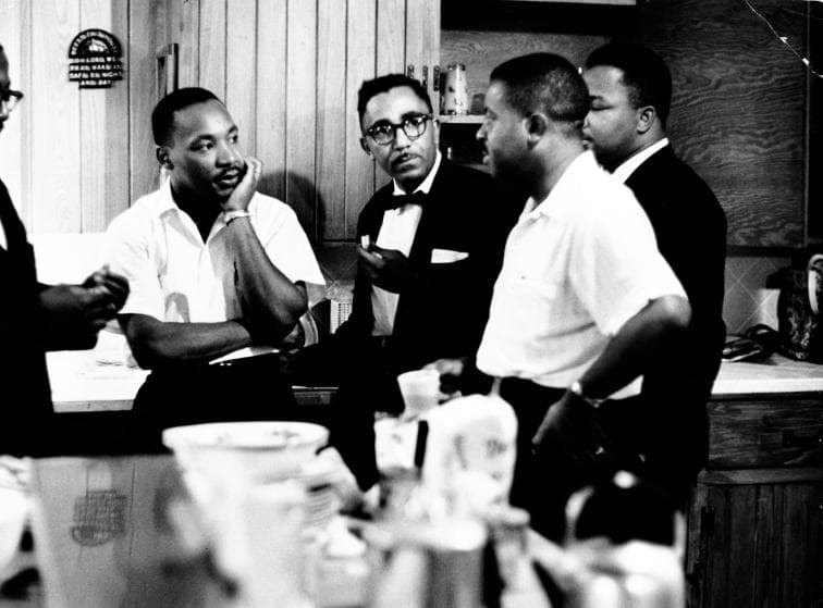 Rev. Martin Luther King Jr. (C) speaking with Rev. Ralph Abernathy (2nd R) and others.