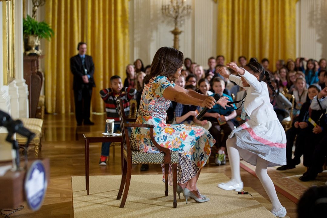 First Lady Michelle Obama reaches out to hug a child attending the annual "Take Our Daughters and Sons to Work Day" event in the East Room of the White House, April 22, 2015. (Official White House Photo by Lawrence Jackson) This official White House photograph is being made available only for publication by news organizations and/or for personal use printing by the subject(s) of the photograph. The photograph may not be manipulated in any way and may not be used in commercial or political materials, advertisements, emails, products, promotions that in any way suggests approval or endorsement of the President, the First Family, or the White House.