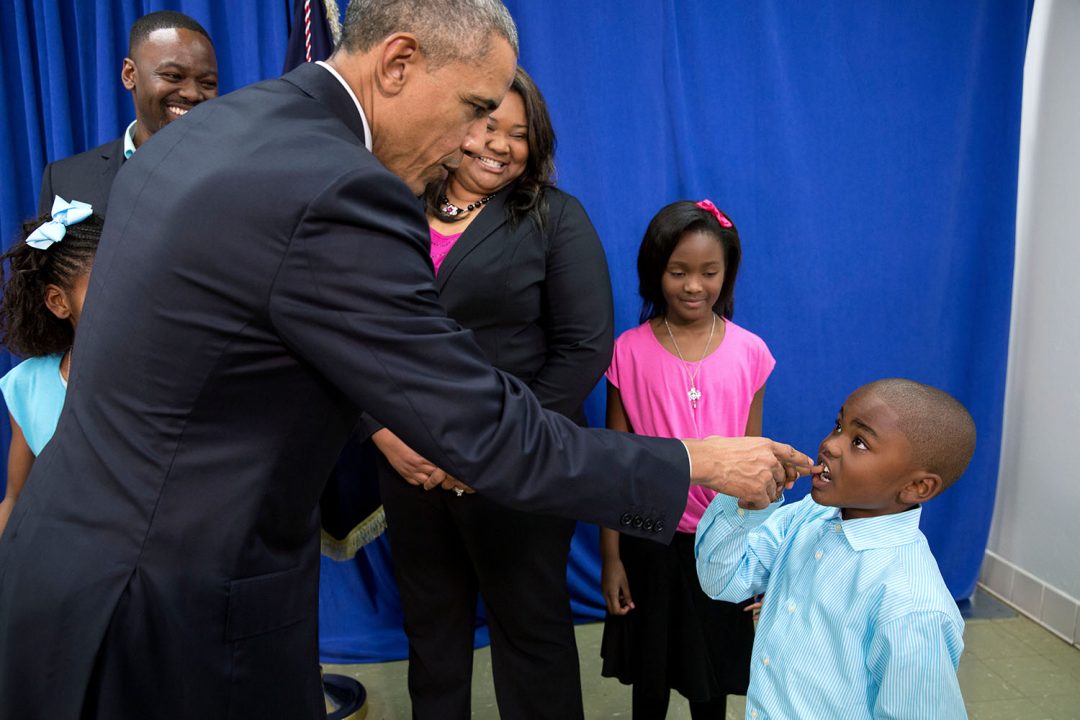 President Barack Obama talks with a young boy about his missing tooth, following a roundtable on consumer protection issues at Lawson State Community College in Birmingham, Ala., March 26, 2015. (Official White House Photo by Pete Souza) This official White House photograph is being made available only for publication by news organizations and/or for personal use printing by the subject(s) of the photograph. The photograph may not be manipulated in any way and may not be used in commercial or political materials, advertisements, emails, products, promotions that in any way suggests approval or endorsement of the President, the First Family, or the White House.