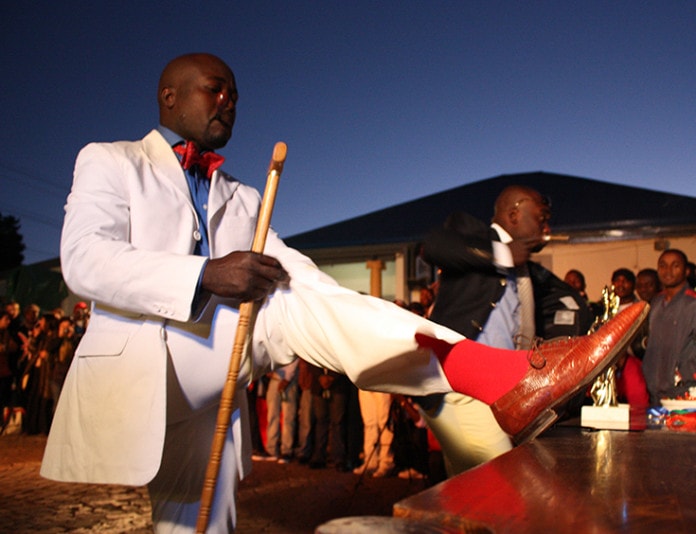A Congolese national parades infront of fans during the La Sape competition at Kin Malebo restaurant, in Yeoville, Johannesburg South Africa, 30 May 2009. Sapeur ('Société des Ambiancé et Personnes Elégants') is a movement which dictates its members to wear European haut couture and was started by musician Papa Wemba. It sprang up after Mobutu Seseko's decree that everyone in Congo was expected to dress in African outfits.