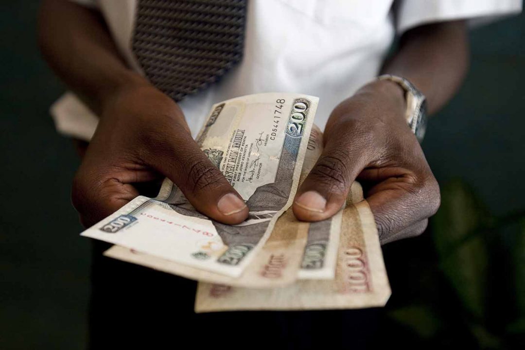 A man counts Kenyan Schillings, the currency of Kenya, in Nairobi, Kenya, on Thursday, Feb. 25, 2010. Kenya National Bureau of Statistics said it will postpone publishing February's inflation data by at least a day or two to prepare for the release of a revised consumer price index basket. Photographer: Trevor Snapp/Bloomberg