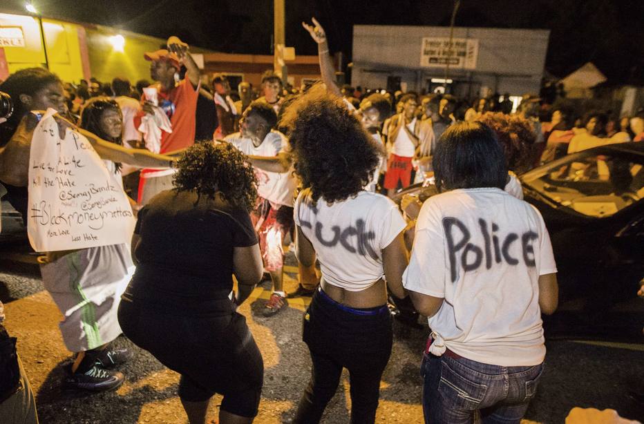 BATON ROUGE, LA -JULY 06: (EDITORS NOTE: Image contains profanity.) Protesters dance in the street near the convenience store where Alton Sterling was shot and killed, July 6, 2016 in Baton Rouge, Louisiana. Sterling was shot by a police officer in front of the Triple S Food Mart in Baton Rouge on Tuesday, July 5, leading the Department of Justice to open a civil rights investigation. Mark Wallheiser/Getty Images/AFP (Photo by Mark Wallheiser/Getty Images) == FOR NEWSPAPERS, INTERNET, TELCOS & TELEVISION USE ONLY ==