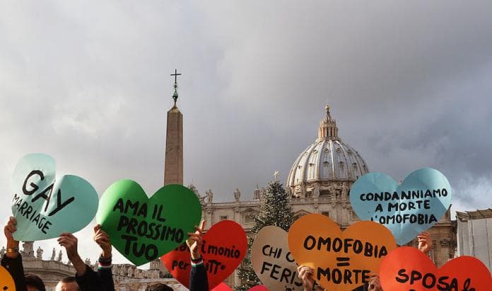 Italian gay movement members demonstrate in front of the Vatican on December 16, 2012, to protest against Pope Benedict's comments regarding the Church's opposition to gay marriage, saying heterosexual marriage had an dispensable role in society. Banners read (LtoR) "love your neighbor ", " Homophobia equal death" "Condemn the homophobia "and "marry the peace". AFP PHOTO / VINCENZO PINTO (Photo credit should read VINCENZO PINTO/AFP/Getty Images)