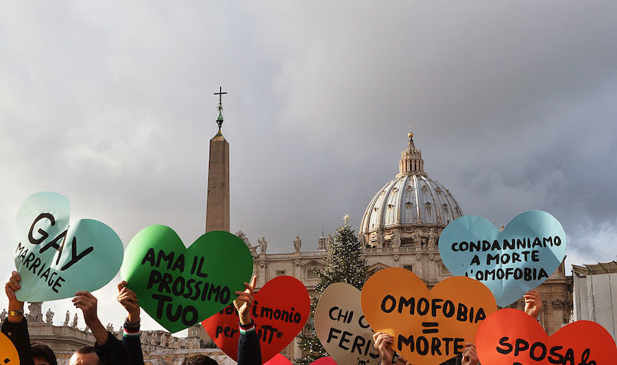 Italian gay movement members demonstrate in front of the Vatican on December 16, 2012, to protest against Pope Benedict's comments regarding the Church's opposition to gay marriage, saying heterosexual marriage had an dispensable role in society. Banners read (LtoR) "love your neighbor ", " Homophobia equal death" "Condemn the homophobia "and "marry the peace". AFP PHOTO / VINCENZO PINTO (Photo credit should read VINCENZO PINTO/AFP/Getty Images)