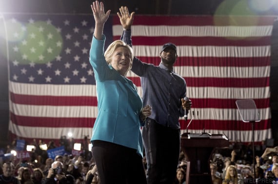 Democratic presidential candidate Hillary Clinton, left, accompanied by LeBron James, right, takes the stage at a rally at the Cleveland Public Auditorium in Cleveland, Sunday, Nov. 6, 2016. (AP Photo/Andrew Harnik)