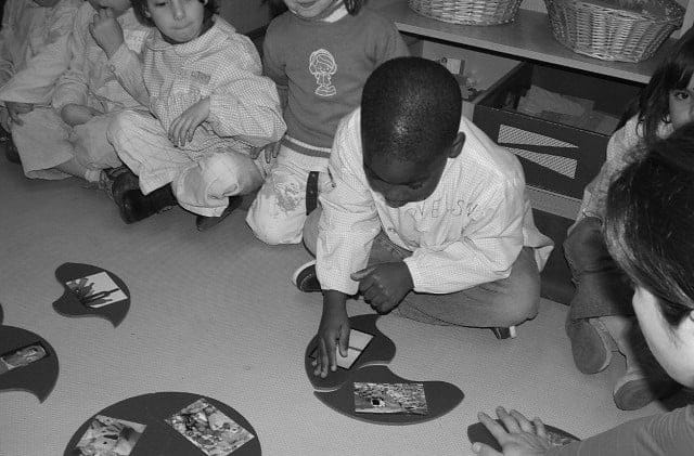 Criança negra montando um jogo na escola