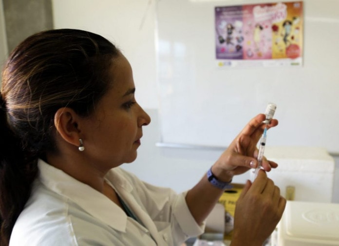 Enfermeira colocando vacina de  HPV na seringa 