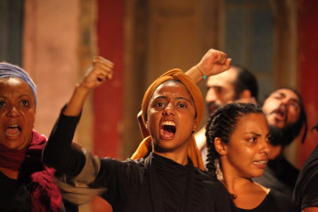 Grupo de atrizes gritando em cena da peça Esperança na Revolta
