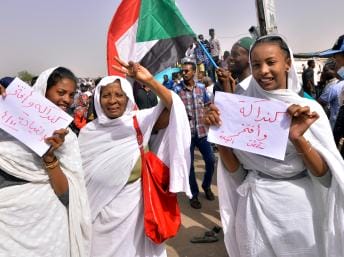 Mulheres sudaneses com cartazes nas mãos.