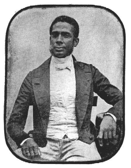 Foto antiga, em preto e branco, de José Mauricio Nunes Garcia Júnior- homem negro, de pouca barba- sentado em uma cadeira 