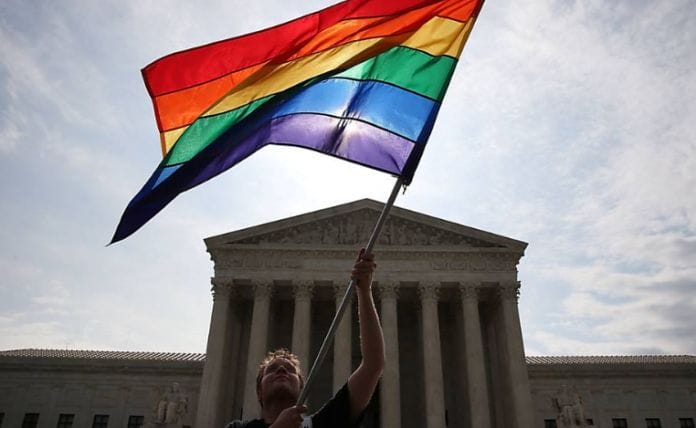 Bandeira com as cores do arco-íris é acenada em frente á Suprema Corte americana, em Washington 