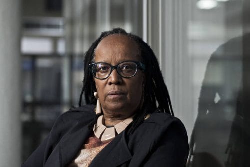 Sueli Carneiro -  mulher negra, usando óculo de grau - sentada olhando para frente 