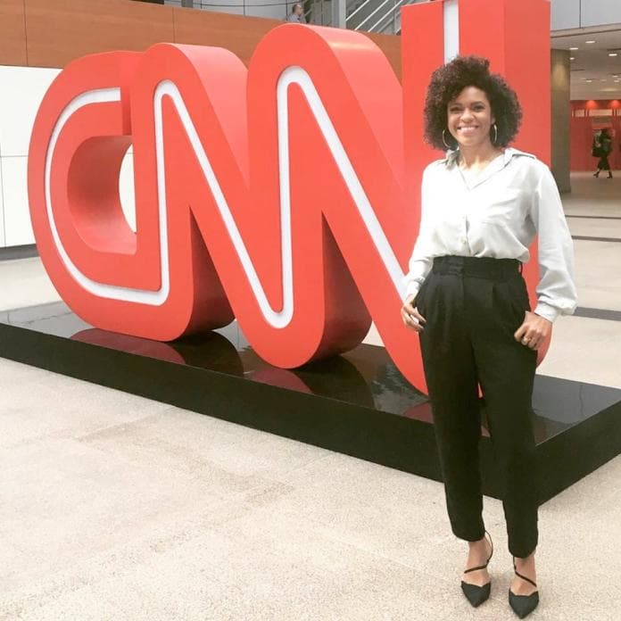 Lucina Barros em pé ao lado do logo da CNN