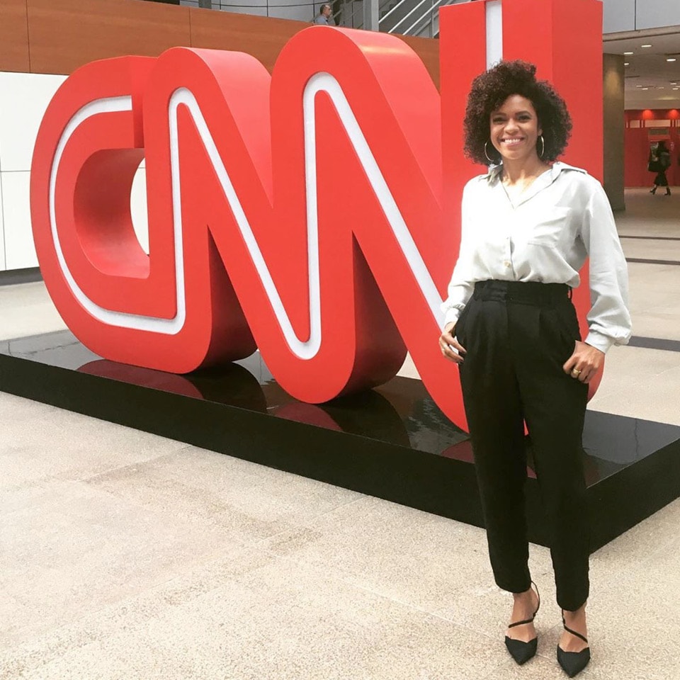 Lucina Barros em pé ao lado do logo da CNN